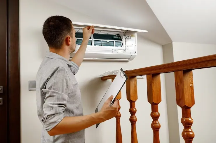 Technician assessing a residential air conditioning system for replacement