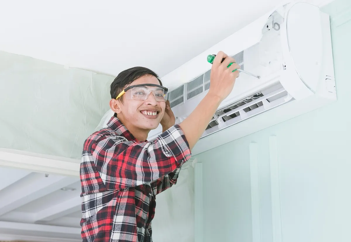Technician installing a split system air conditioner indoor unit